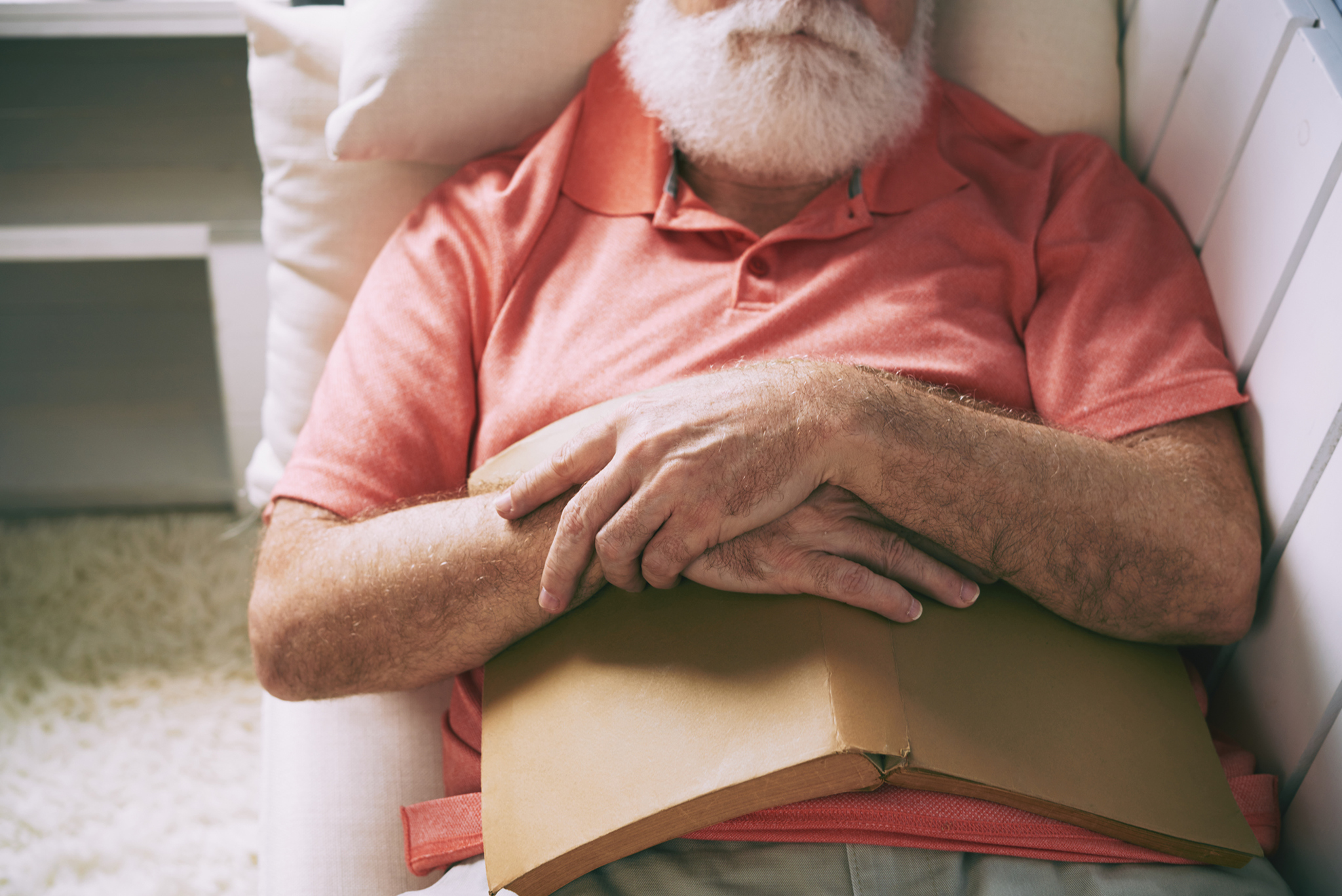 Senior man fell asleep on sofa after reading book