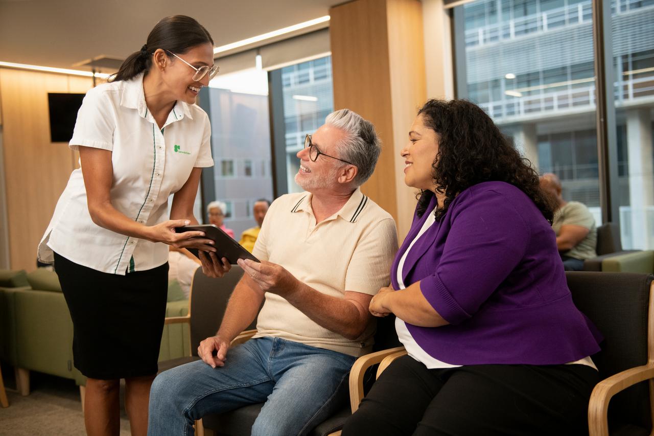 GenesisCare centre staff helping patient and carer