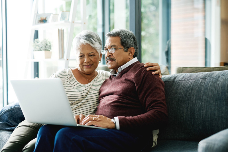 Shot of a mature couple using a laptop while relaxing at home